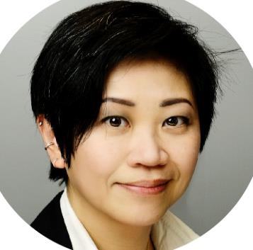 Headshot of a woman with short dark hair, wearing a white shirt and dark jacket, smiling slightly.